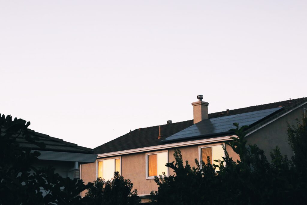 A house with solar panels on its roof. Grey sky.